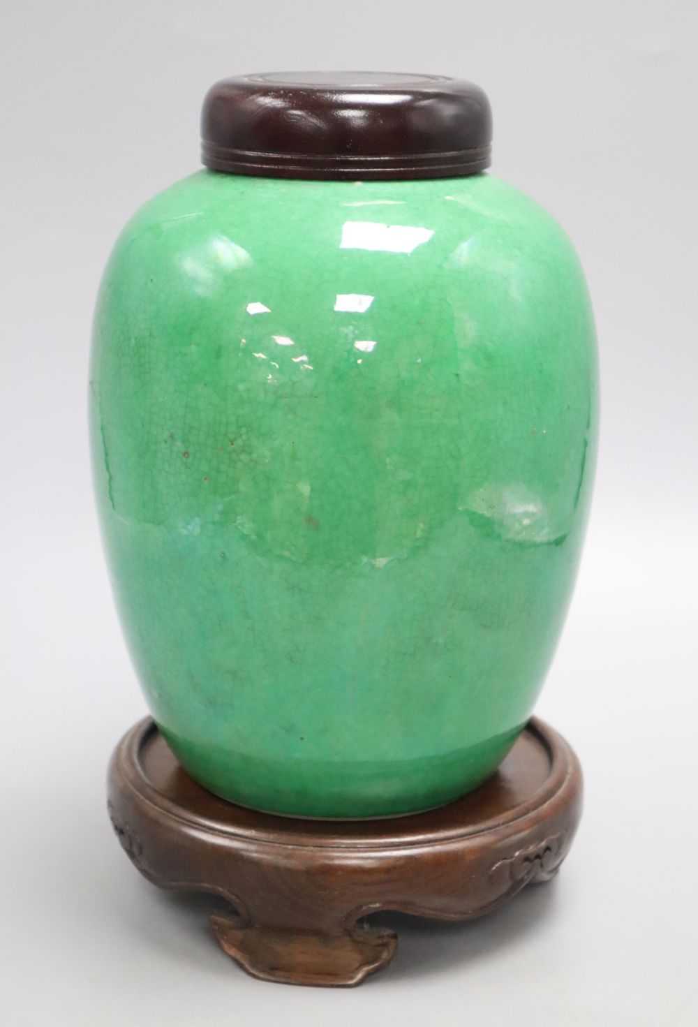 A 19th century Chinese green crackle glaze jar, drilled, wood cover and stand, overall height 25cm